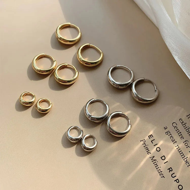 Women's minimalist water drop earrings in electroplated gold or silver copper, showing geometric shape and round elements.