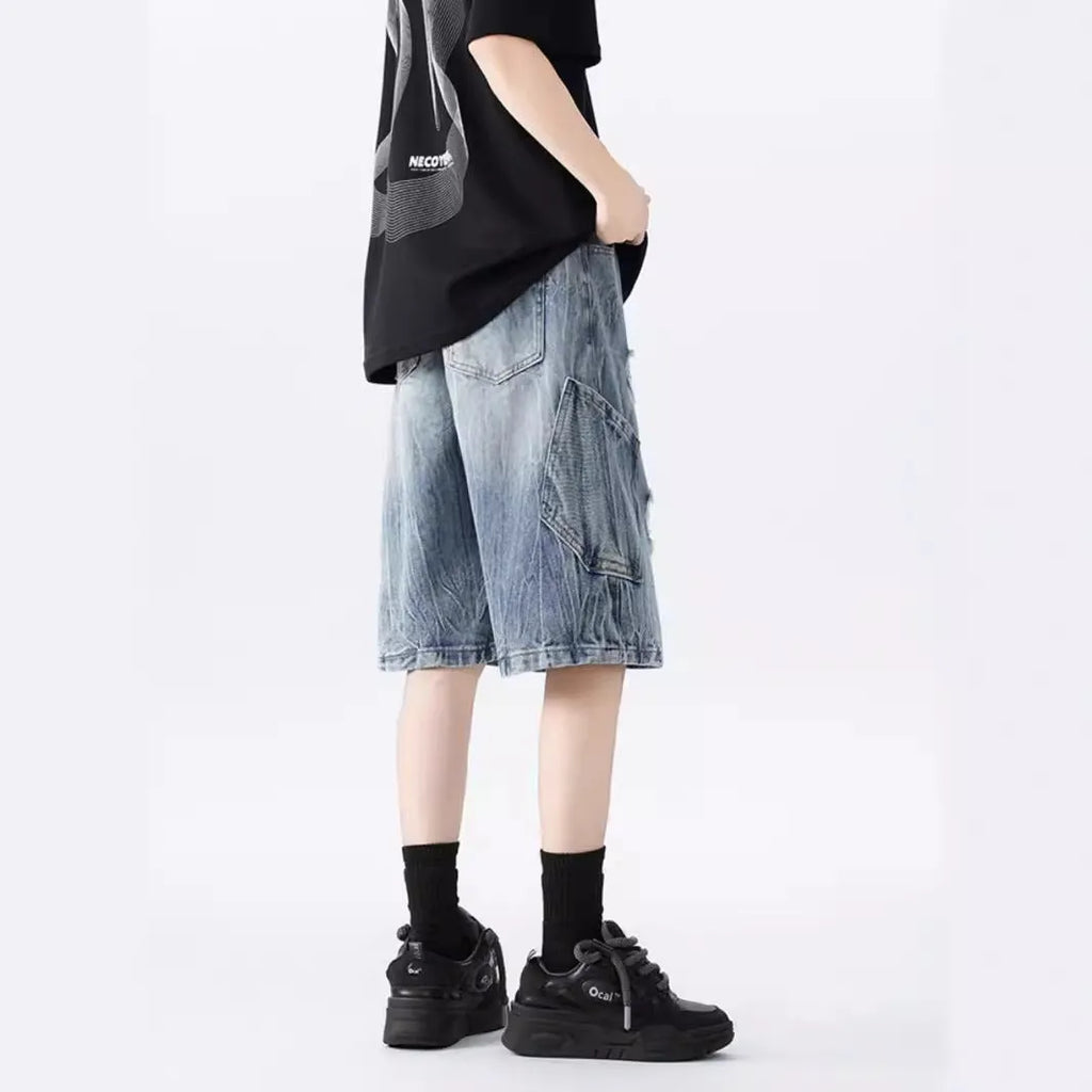 Men's ripped denim shorts with washed finish in black and blue colours showing loose fit design