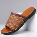 Men's breathable PU leather slippers in black with flat heel and round toe, side view
