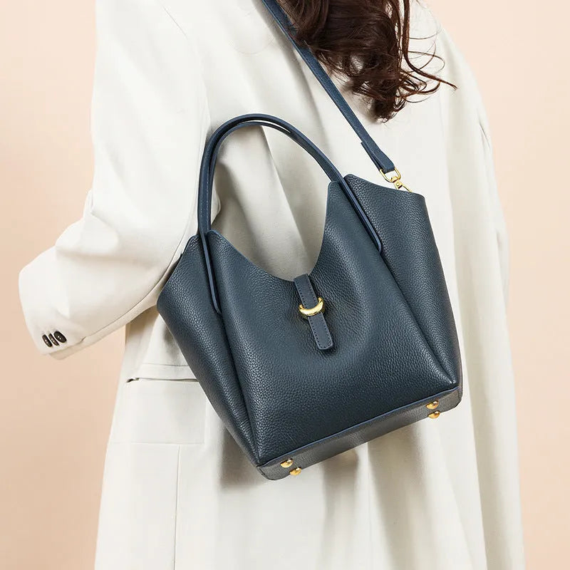 Genuine leather women's hand holding bucket bag in retro style with file compartment interior.