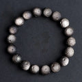 Natural obsidian crater ball bracelet showing textured beads in silver stone or golden obsidian colour on a wrist.