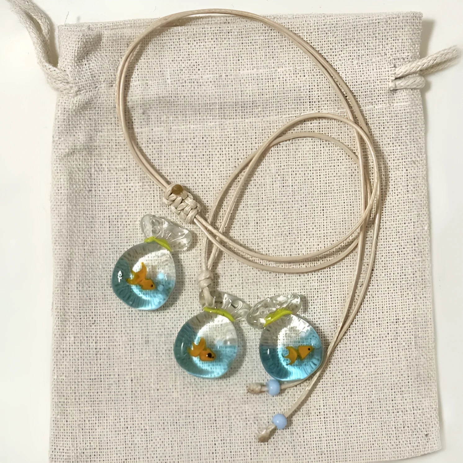 Women's joker pendant necklace with coloured glaze ornament on a cotton and linen clavicle chain.