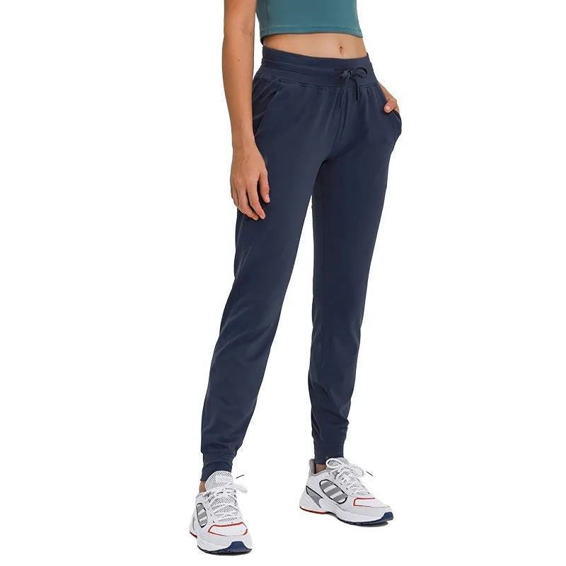 Women's high waist black yoga pants with drawstring detail, shown on a model.