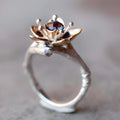 Silver two-tone alloy ring with geometric floral design on a white background.