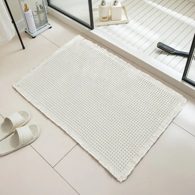 Square checkered pattern bathroom carpet on tiled floor in light grey colour.