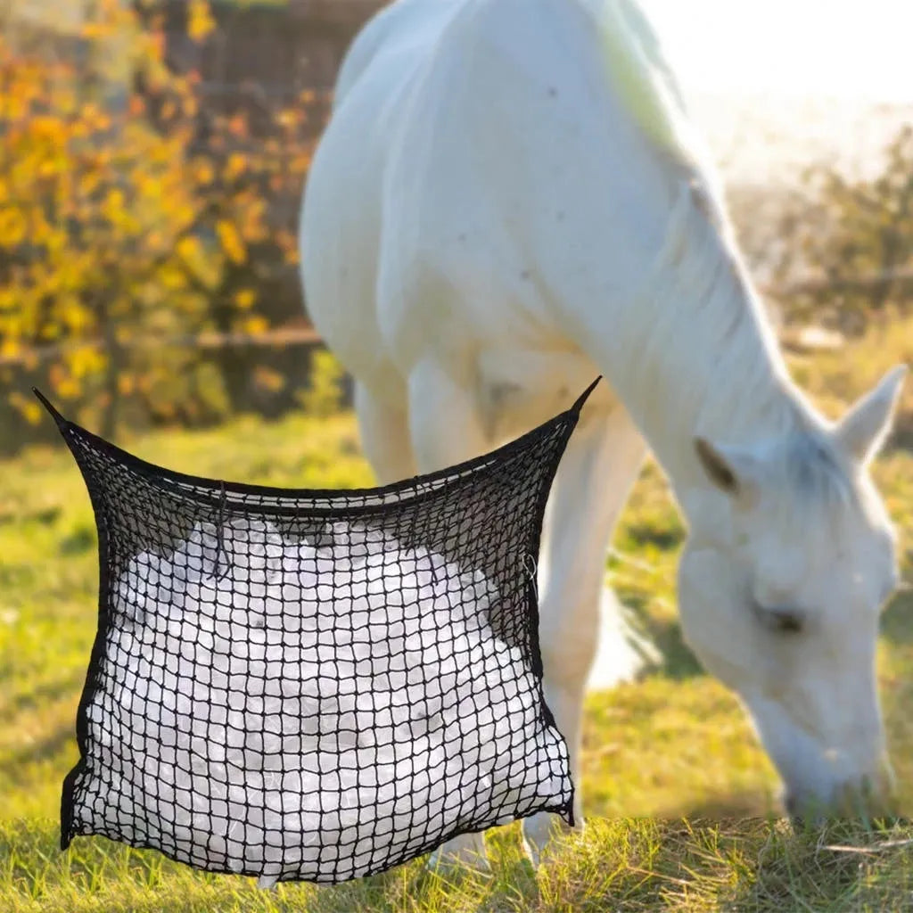 Black woven PE rope mesh feeding bag for horses hanging on a fence
