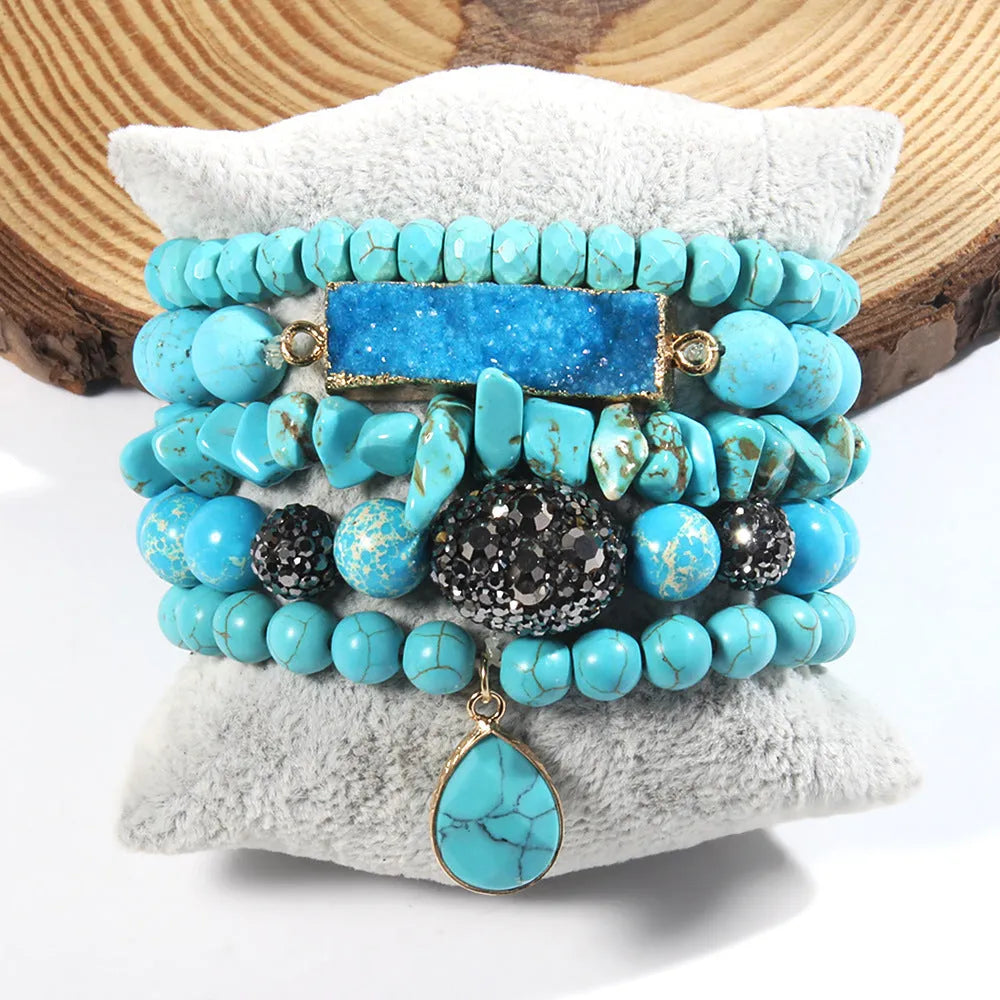 Set of five handmade stretch bracelets with glass, crystal, and hematite beads in irregular shapes on a neutral background