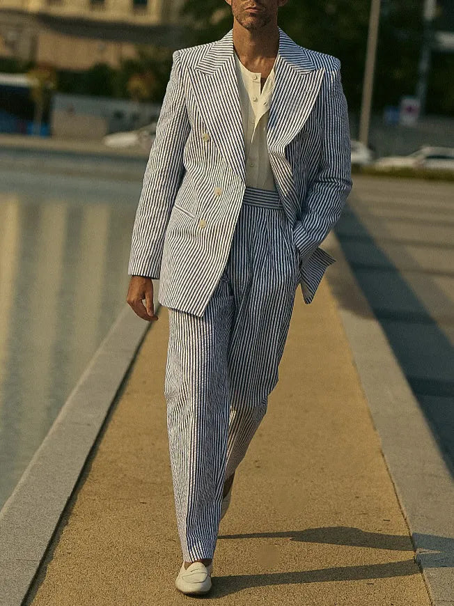 Blue and white striped polyester blazer and trousers suit set laid flat.