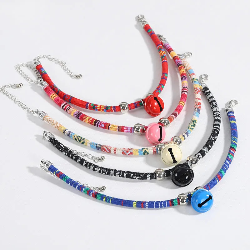 Coloured ethnic pattern adjustable pet collar for dogs and cats with a small metal bell attached.