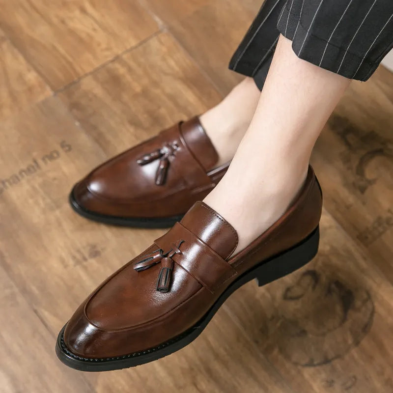 Men's black and brown tassel loafers with a slip-on design and rubber sole for business casual wear.