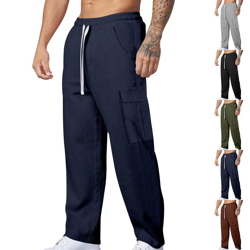 Men's navy blue corduroy cargo trousers with wide-leg design and drawstring waist laid flat.
