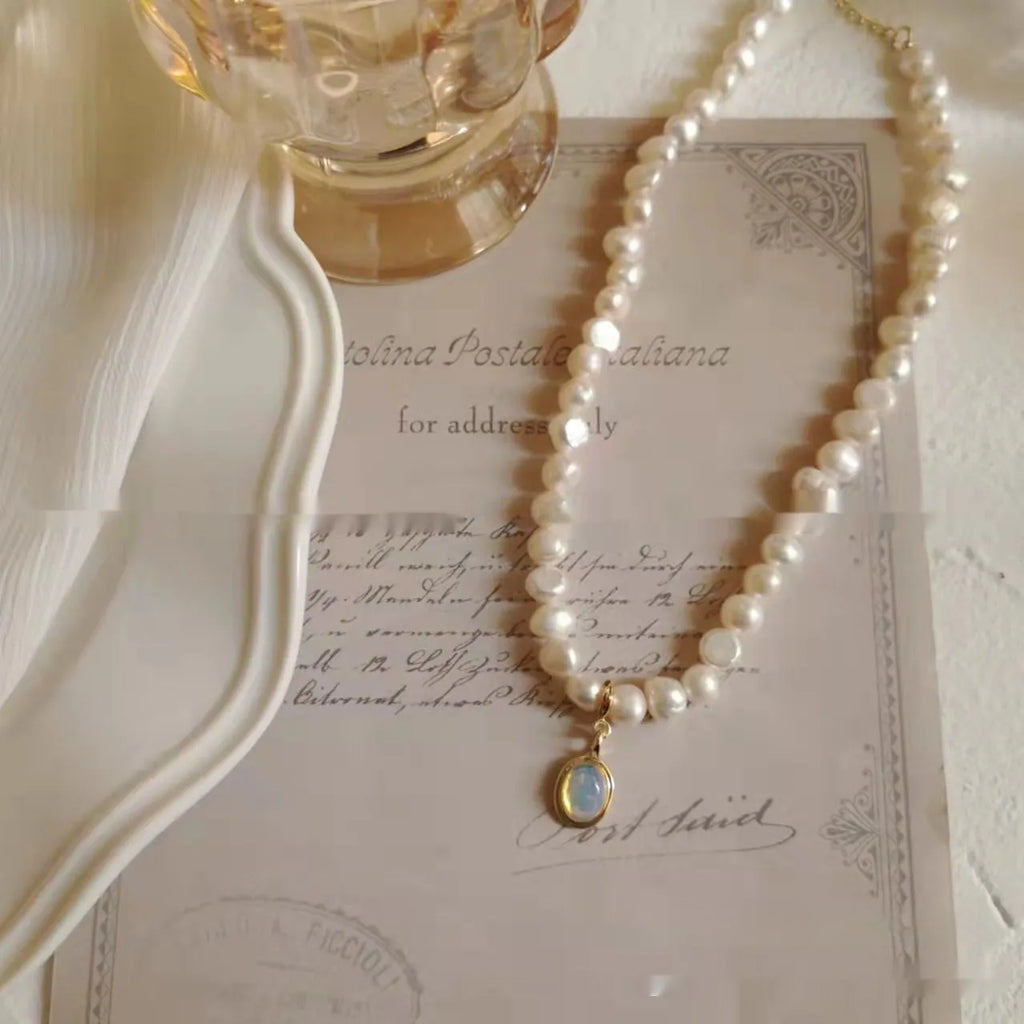 Adjustable vintage pearl necklace with geometric design on a grey background.