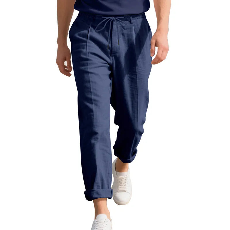 Man wearing light khaki straight-leg linen trousers with a drawstring waist.