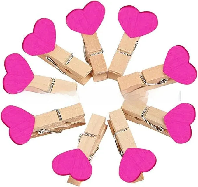 Five wooden heart-shaped hair clips in different colours on white background