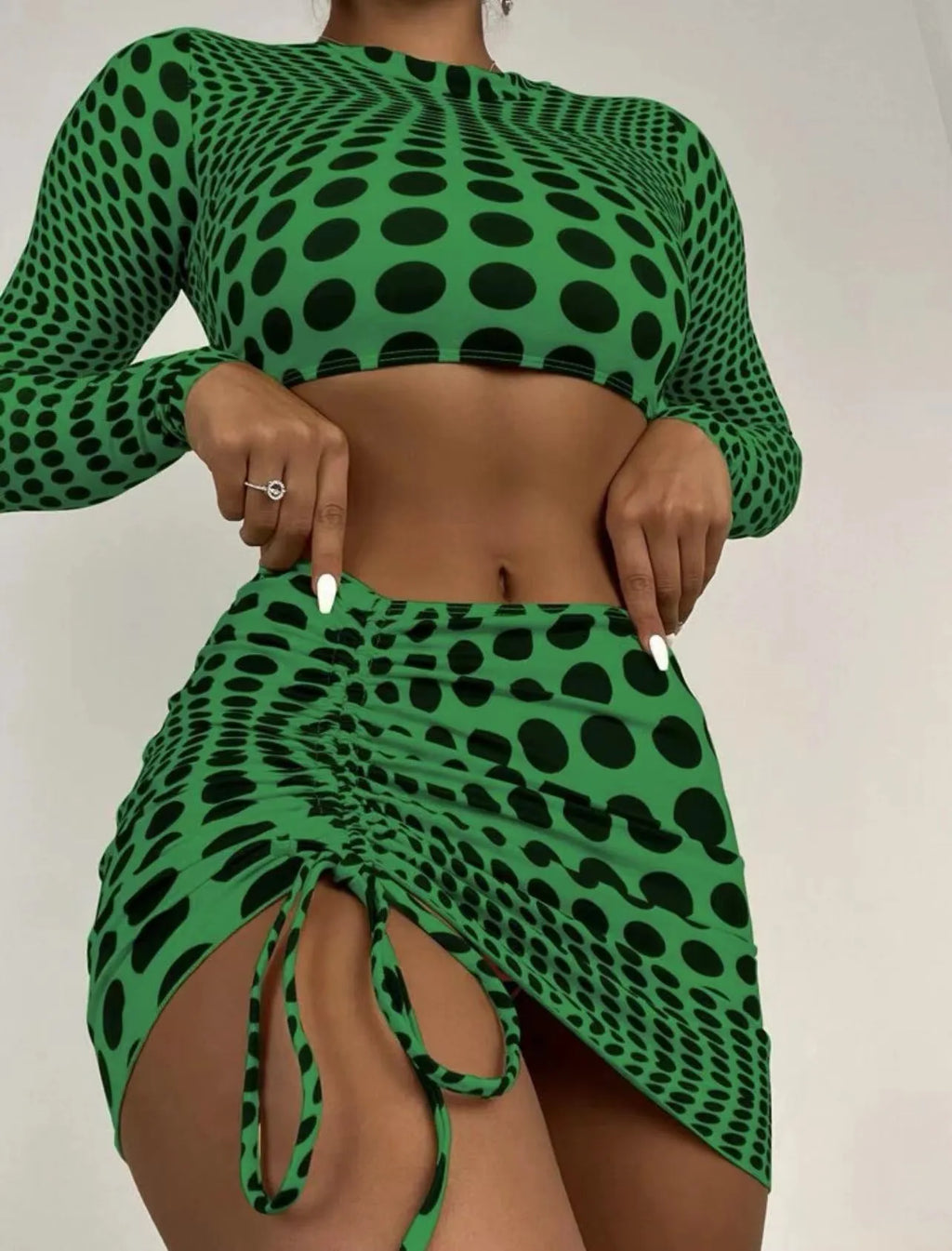 Green polka dot women's three-piece swimsuit set showing bikini top, skirt, and bra.