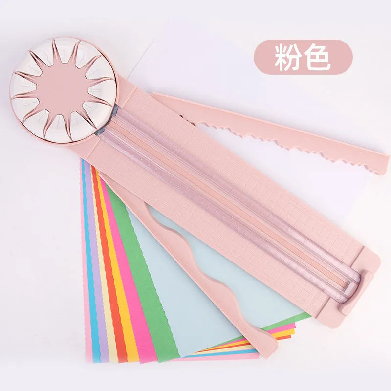 Pink 12-in-1 paper cutting machine with interchangeable blades for scrapbooking on white background