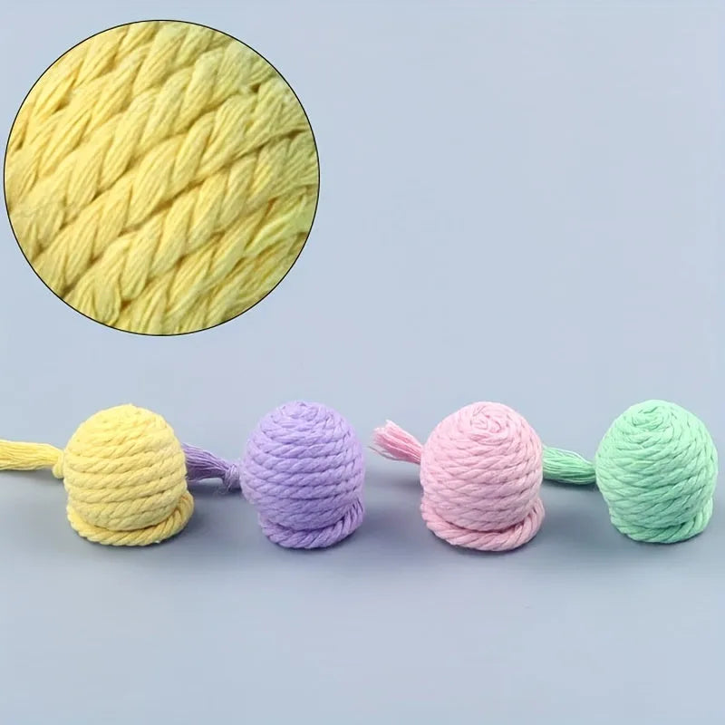 Green and pink plastic cat toy balls with ropes and internal bells.