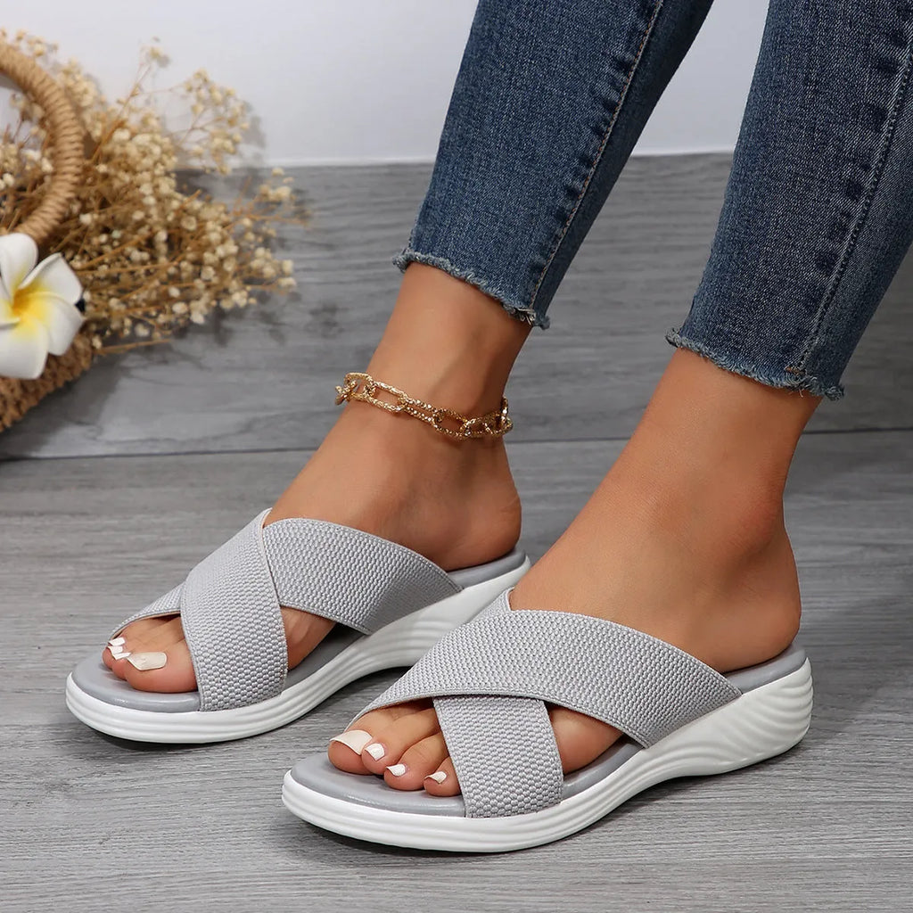 Black women's flat wedge peep-toe slippers with a thick rubber sole and PVC upper.