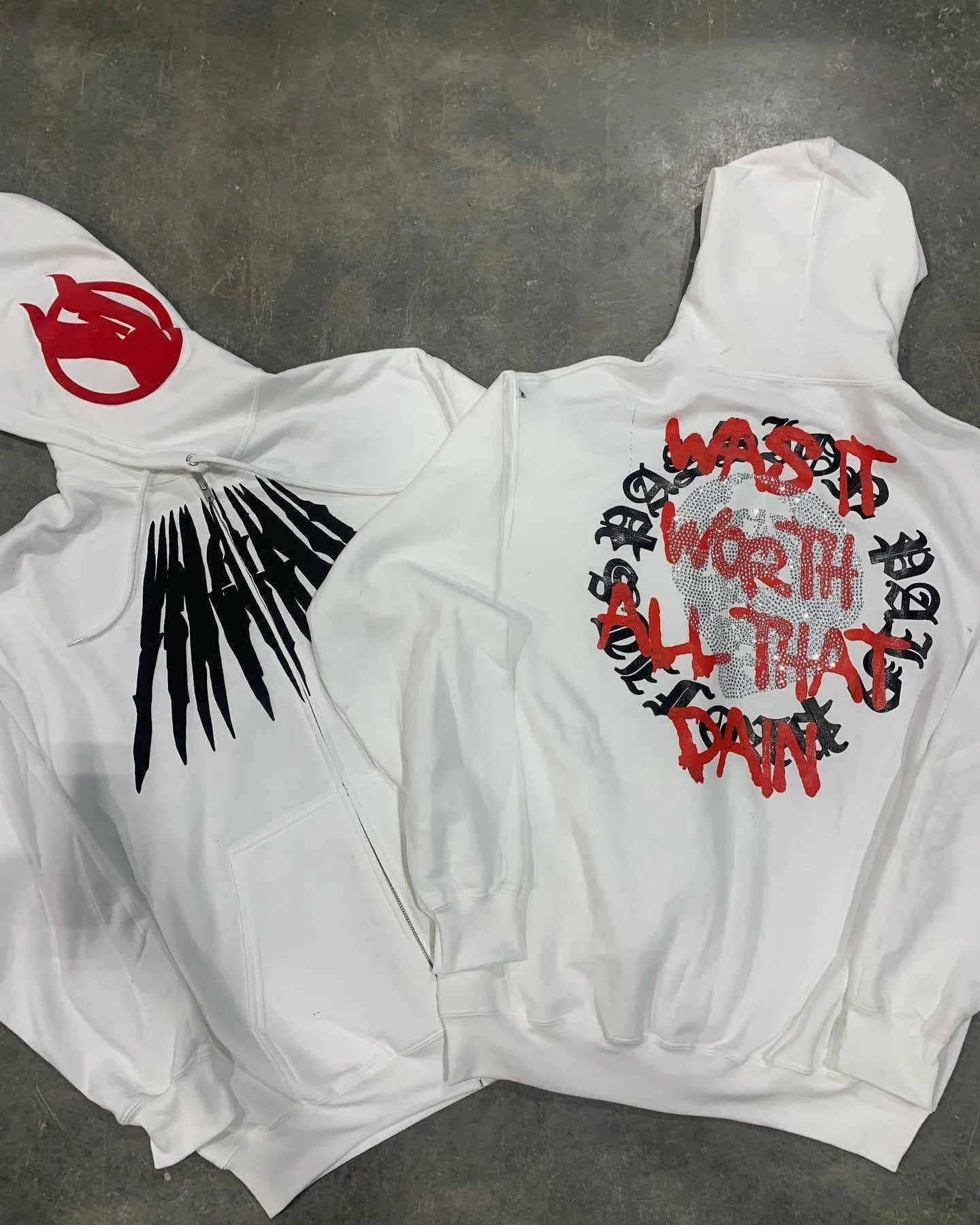 Black hooded sweatshirt with white printed skull design and rhinestone details, loose cardigan style
