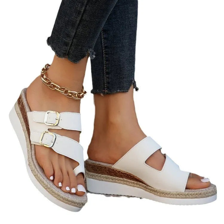 White patent leather women's wedge sandals with a woven design and peep toe on a rubber sole.