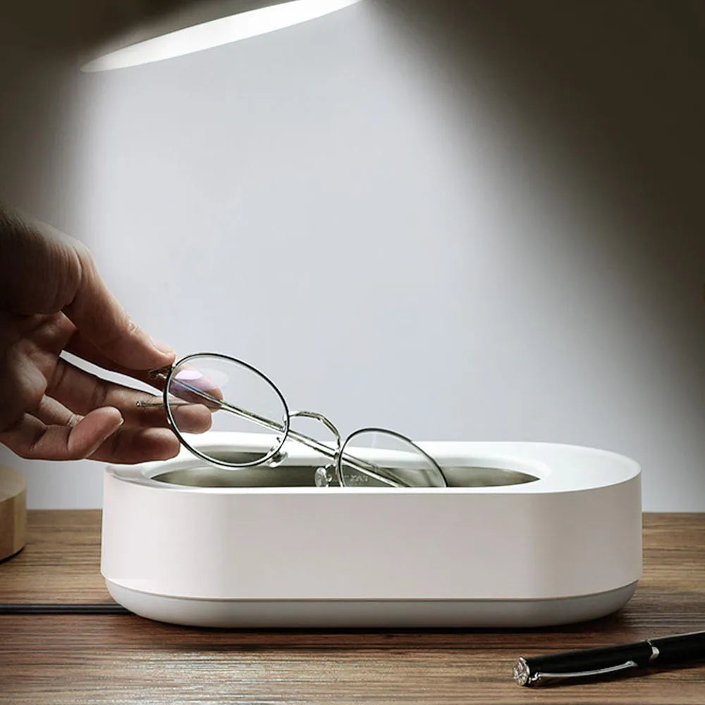White portable ultrasonic cleaner with digital display and stainless steel cleaning tank.