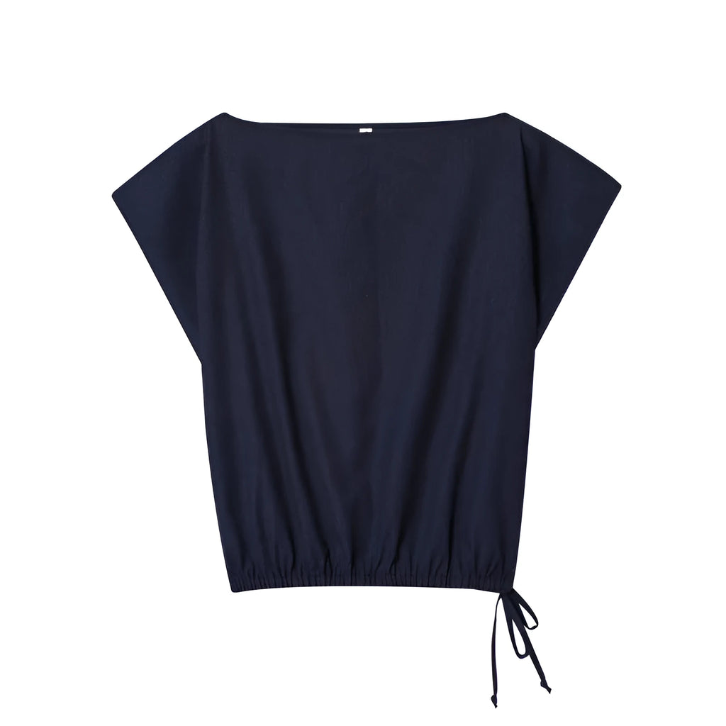 Women's linen blend co-ord set showing flounced sleeve off-neck top with wide leg trousers in temperament commute style
