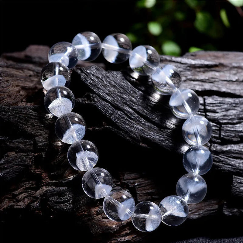 Women's white crystal pyramid bead bracelet with a Ruyi charm on a wrist.