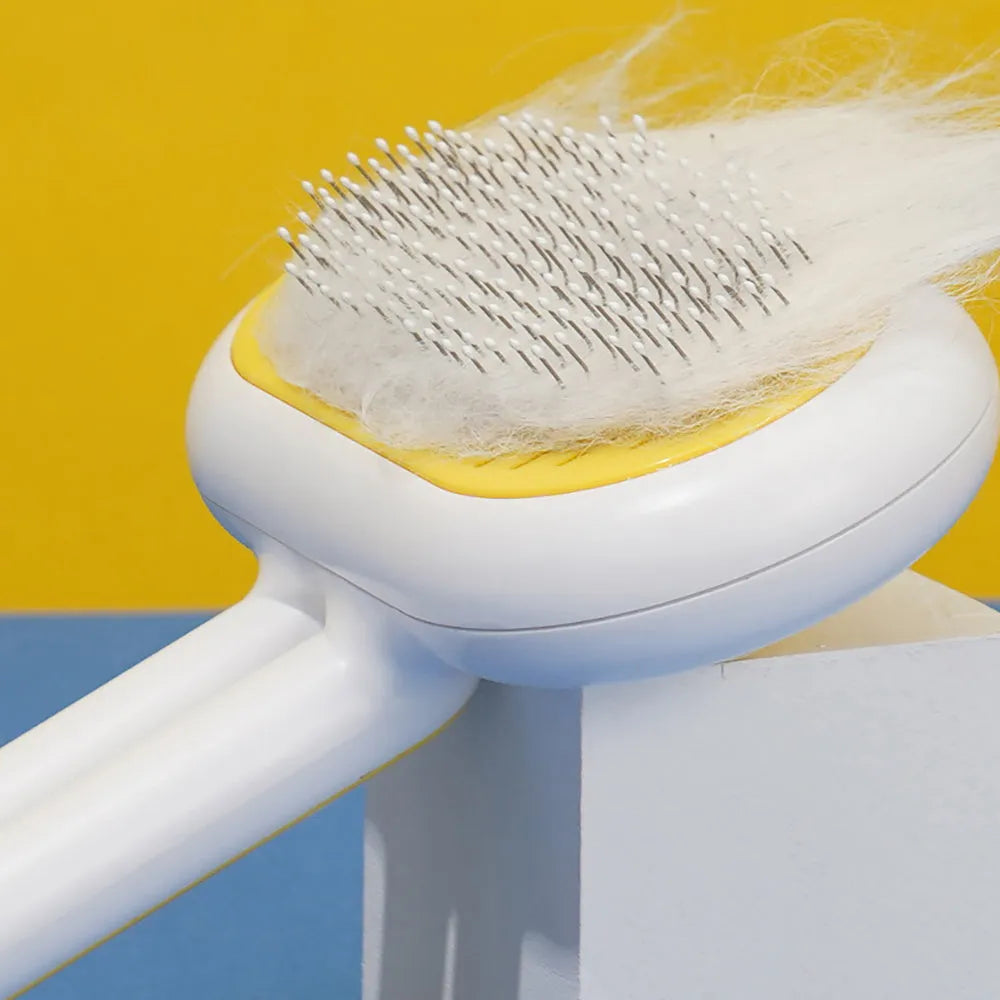 Cat dog grooming brush with stainless steel teeth and white silicone tips on a gray handle