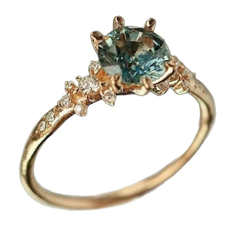 Gold geometric claw ring with inlaid zircon stones on a chamfered square band.