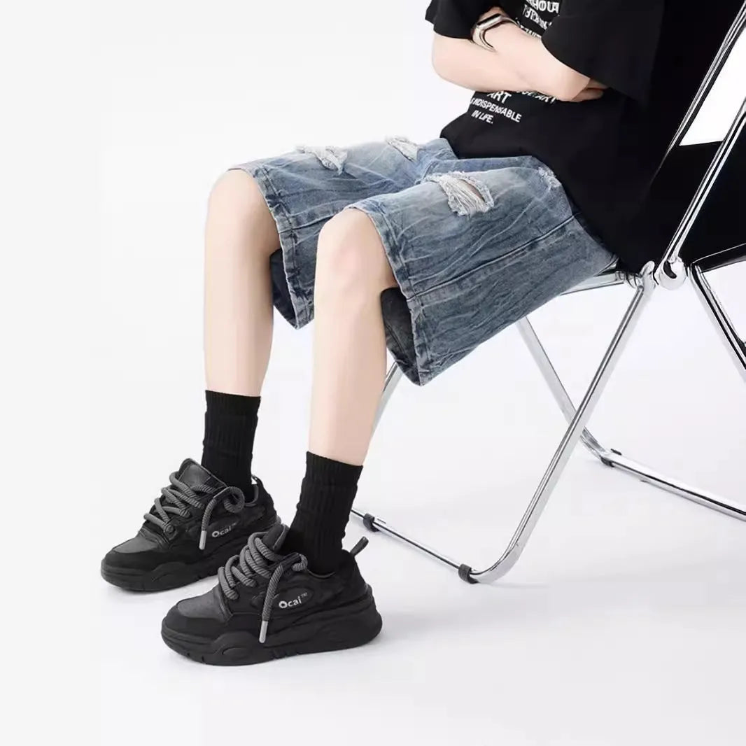 Men's ripped denim shorts with washed finish in black and blue colours showing loose fit design