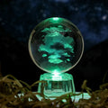 Transparent 6cm crystal ball ornament with internal laser carving and LED illumination on fixed base