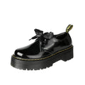 Women's black leather lace-up shoes with thick soles and cross-strap ribbons on the upper.