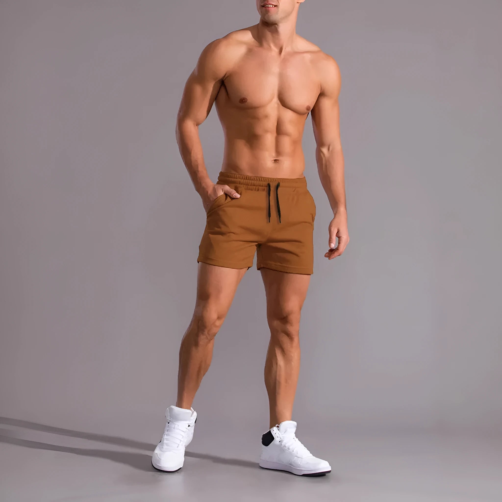 Set of three solid colour men's drawstring shorts in black, khaki, and light brown laid flat.