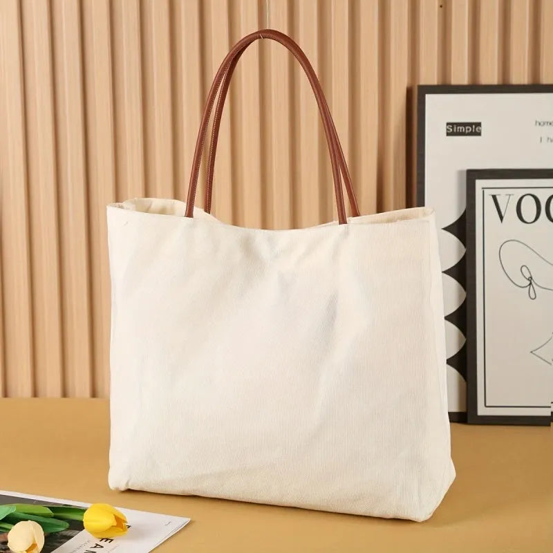 Beige white canvas tote bag with cotton handles, showing interior patch pocket and exterior zipper pocket.