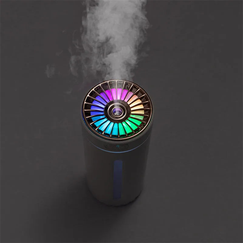 Compact black wireless humidifier with colourful LED lights sitting in car cup holder