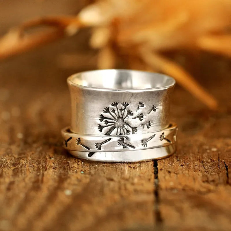 Silver coloured rotatable floral fashion ring on a hand, showing the spinning flower design.