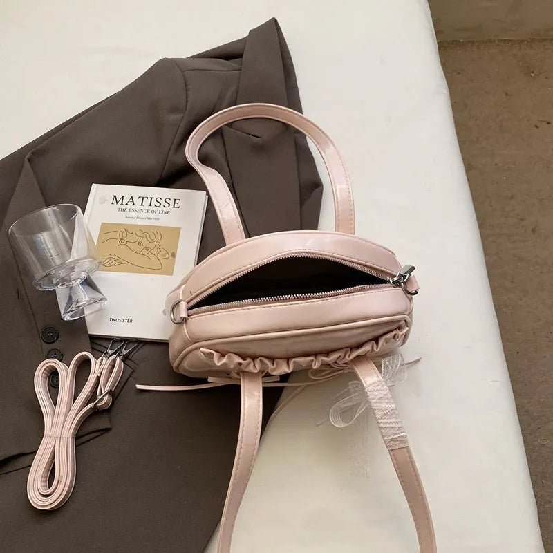 Women's casual PU leather handbag with a bandage bow decoration on the front.
