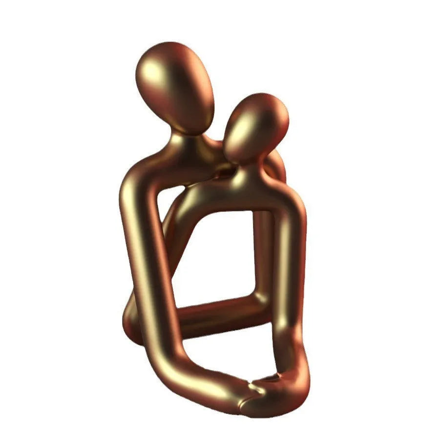 Modern loving couple resin statue in milky white or gold on a bookshelf.