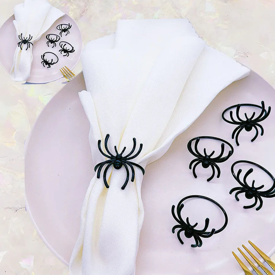 Six black alloy spider-shaped napkin rings for Halloween table settings.